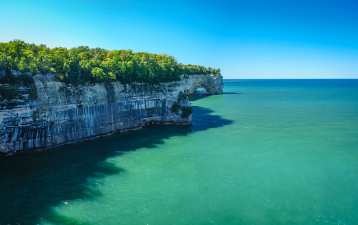 The cliffs of Pictured Rocks National Lakeshore with a picture perfect blue sky and calm Lake Superior.