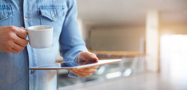 hombre de las manos sosteniendo la tableta digital blanco y taza de café - cafe laptop espresso business fotografías e imágenes de stock