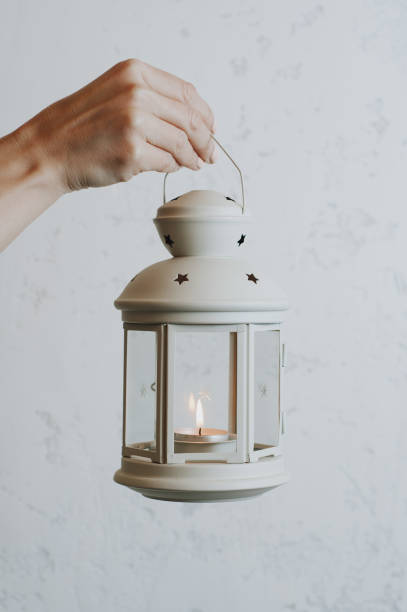 istock Woman holding a Christmas lantern on a white wall background 1070128196