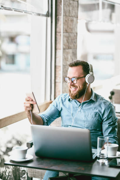 istock Handsome Male Freelancer Making A Video Call While Working In Cafeteria 1070132294