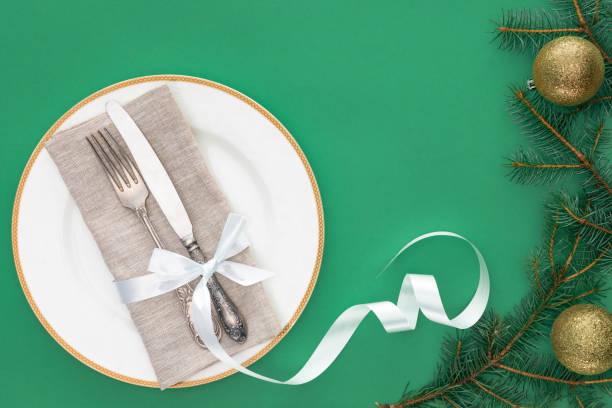 istock flat lay with fork and knife wrapped by festive ribbon on plate near evergreen tree branches with christmas balls isolated on blue 1070134056