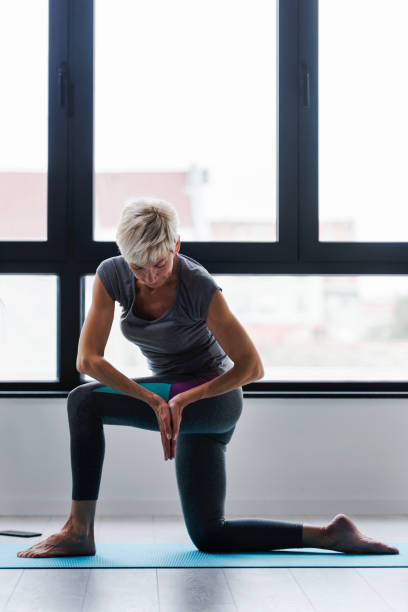 istock Active elderly woman practicing yoga indoors 1070137778