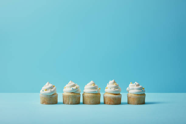 istock Delicious cupcakes with sugar sprinkles on blue background 1070141650