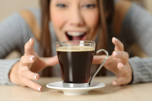 mulher espantada a olhar para uma xícara de café - molécula de cafeína - fotografias e filmes do acervo