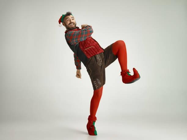 friendly man dressed like a funny gnome posing on an isolated gray background
