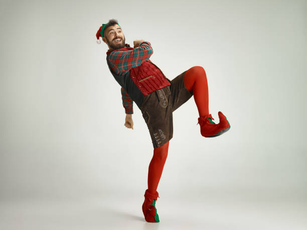 friendly man dressed like a funny gnome posing on an isolated gray background friendly man dressed like a funny gnome elf photos stock pictures, royalty-free photos & images