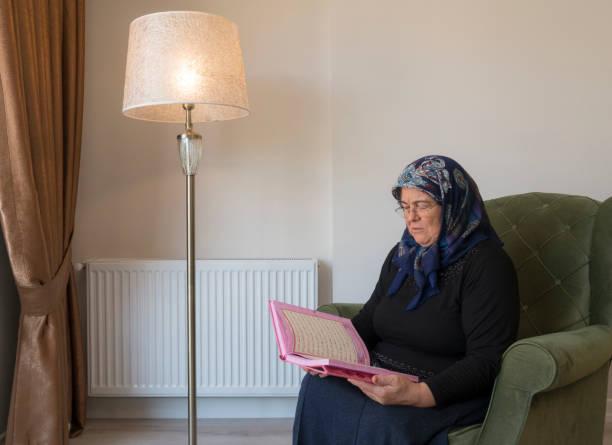 muslim woman reading holy koran - cairo mosque egypt inside of imagens e fotografias de stock