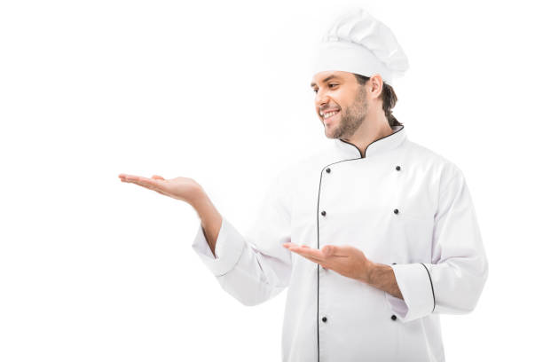 istock smiling young chef pointing at blank space isolated on white 1070152960