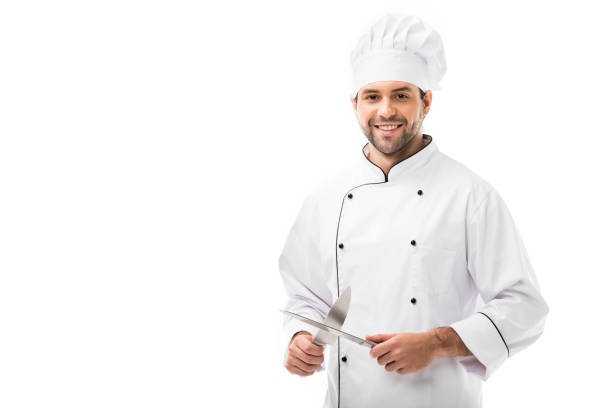 istock handsome young chef holding cutting knives and looking at camera isolated on white 1070153084
