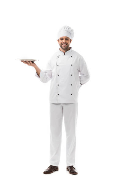 istock happy young chef holding empty plate and looking at camera isolated on white 1070153976