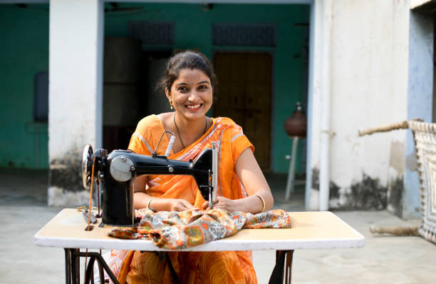 donna che cuce vestiti con macchina da cucire - sewing tailor sewing machine women foto e immagini stock