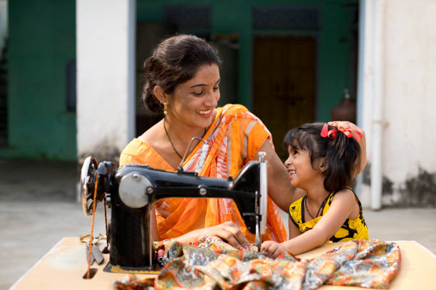 Mother and daughter sewing clothes with sewing machine