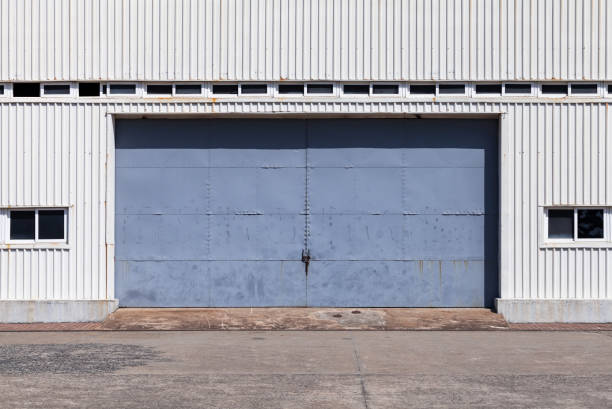 istock Blue gate in white metal warehouse wall 1070156344