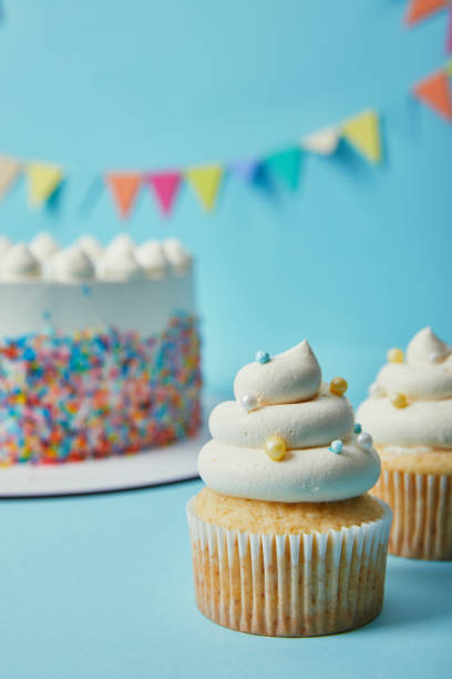istock Delicious cupcake with sugar sprinkles on blue background with cake and bunting 1070158968