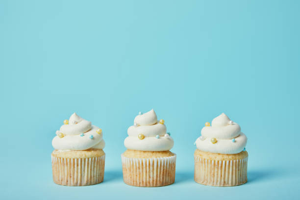 istock Tasty cupcakes with sugar sprinkles on blue background 1070158976