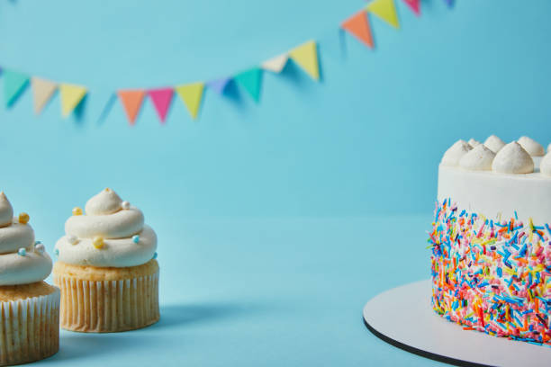 istock Tasty cupcakes and cake on blue background with bunting 1070158992