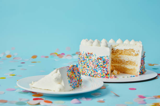 istock Slice of cake with cut cake on blue background with confetti 1070159320