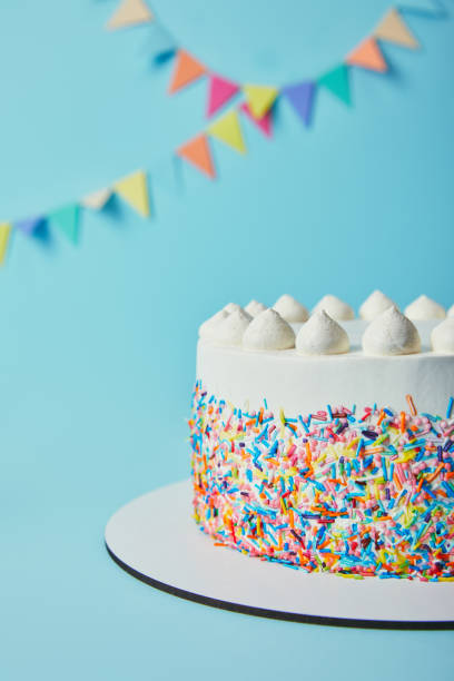 istock Delicious cake with sugar sprinkles and meringues on blue background 1070159652
