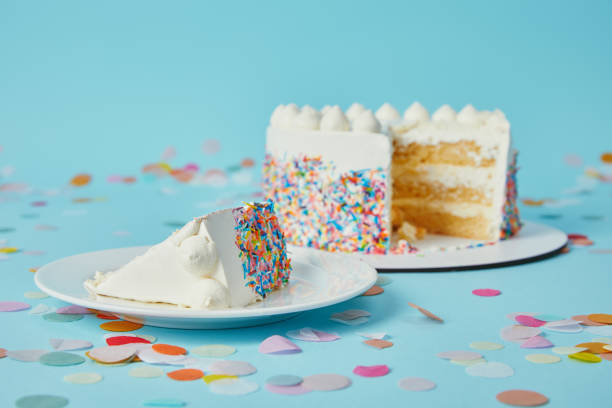 istock Piece of cake with cut cake on blue background with confetti 1070159660