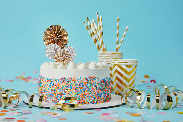 istock Delicious cake, plactic cups and drinking straws on blue background with confetti 1070159682