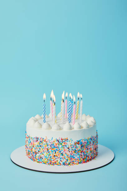 istock Tasty birthday cake with lighting candles on blue background 1070159778
