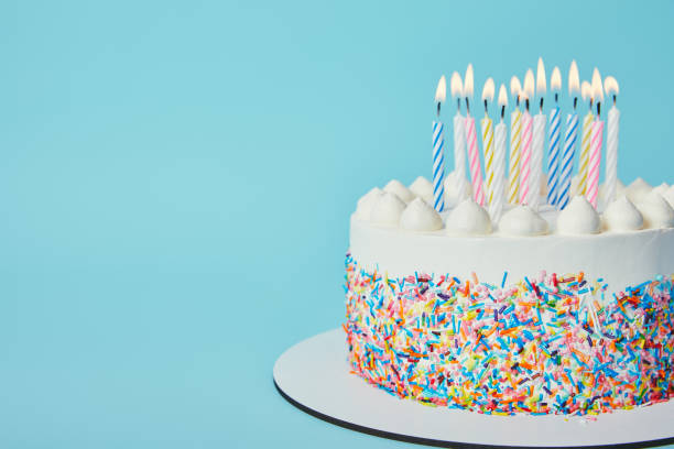 istock Delicious Birthday cake with lighting candles on blue background 1070160106