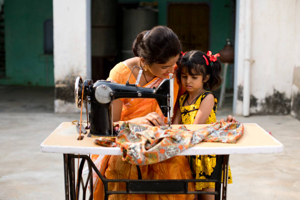 istock Mother and daughter sewing clothes with sewing machine 1070162534