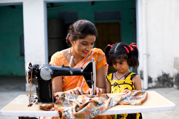 istock Mother and daughter sewing clothes with sewing machine 1070162566