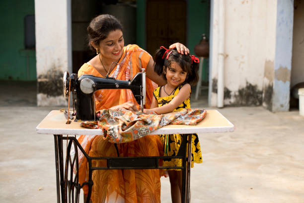 istock Mother and daughter sewing clothes with sewing machine 1070163008