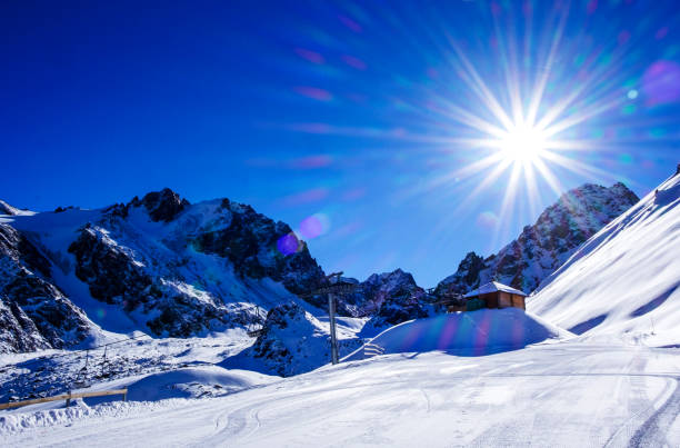 piękny zimowy górski krajobraz, gwiazda słońca na błękitnym niebie - alatau zdjęcia i obrazy z banku zdjęć