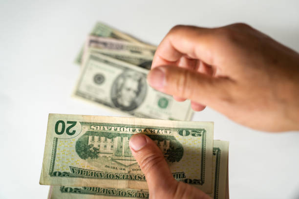 istock Selective focus of hands counting dollar bills isolated on white background. Counting or spending money. 1070171336
