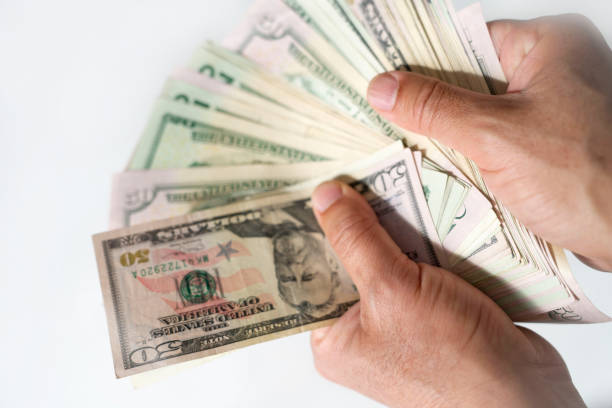 istock Hand holding dollar bills with white background 1070173268