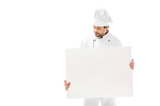 istock professional young chef holding blank banner and looking down isolated on white 1070174482