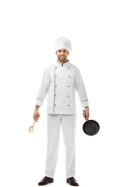 istock professional young chef holding utensils above head and smiling at camera isolated on white 1070175666