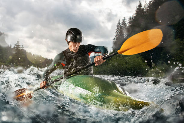 kayak whitewater, kayak estremo. un ragazzo in kayak naviga su un fiume di montagna - river sports foto e immagini stock
