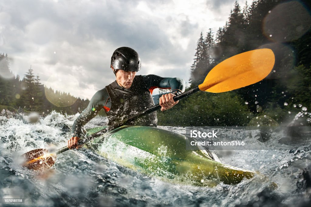 Whitewater kayaking, extreme kayaking. A guy in a kayak sails on a mountain river Kayaking Stock Photo