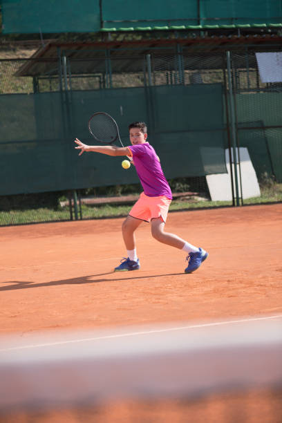 istock Young tennis player hitting the ball 1070185420