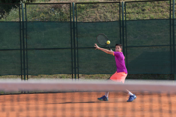 istock Young tennis player hitting the ball 1070185438