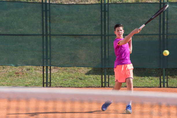 istock Young tennis player hitting the ball 1070185664