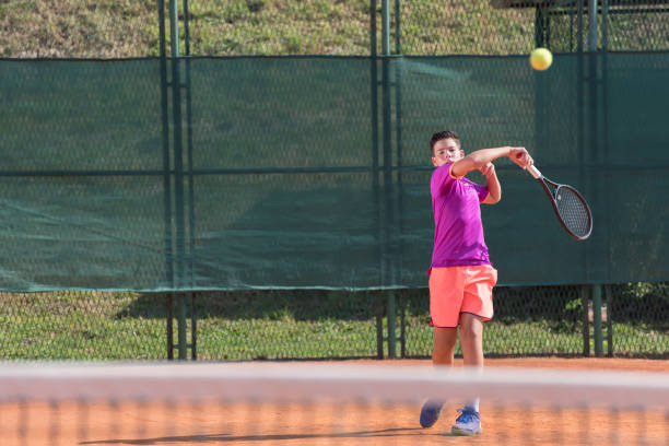 istock Young tennis player hitting the ball 1070185834
