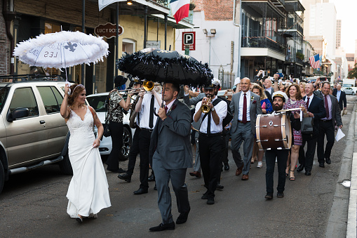 New Orleans, USA - Nov 3, 2018: A Nola second line dancing through the French quarter late in the day on Royal street.