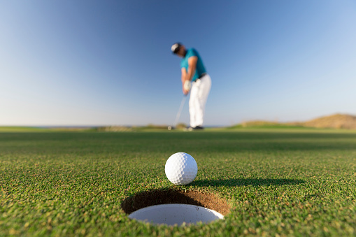 Pelota de golf entrando en el agujero después del exitoso movimiento - Close up - Links Golf photo