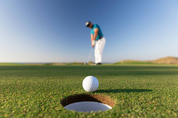 мяч для гольфа ввода отверстие после успешного удара - крупным планом - ссылки гольф - sports flag фотографии стоковые фото и изображения