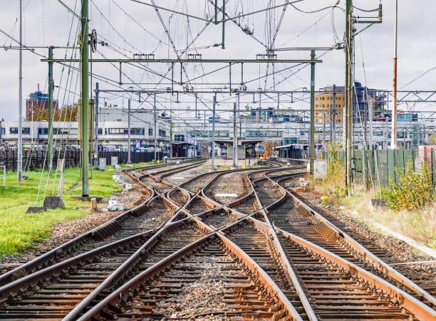 An abstract view of railway tracks leading to a busy station. Railway lines crossing each other leading to Alkmaar central station in the Netherlands railway signal stock pictures, royalty-free photos & images