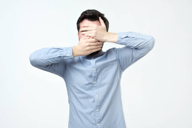 istock Man in blue shirt covered his face with his hands 1070200520