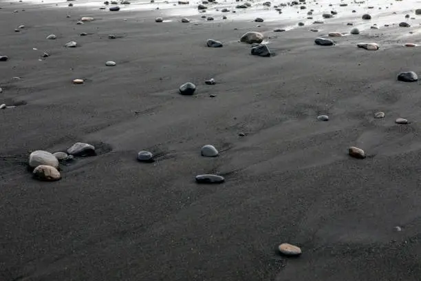 A view of the black sand and pebbles on Reynisfjara Beach, near the fishing village of Vik on the south coast of Iceland.