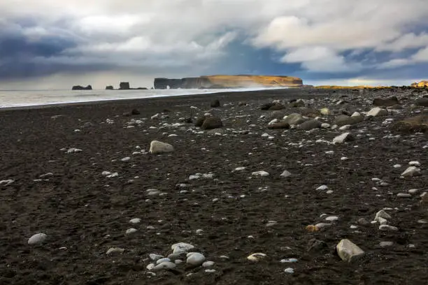 A view of the black sand and rugged coastline on Reynisfjara Beach, near the fishing village of Vik on the south coast of Iceland.
