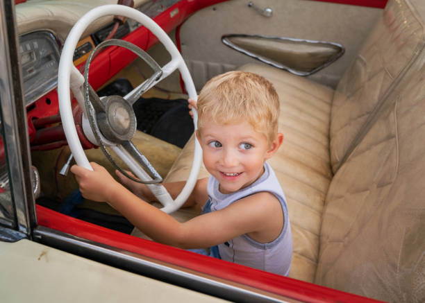 ragazzo seduto sulla vecchia auto americana anni '50 / '60 - taxi retro revival havana car foto e immagini stock