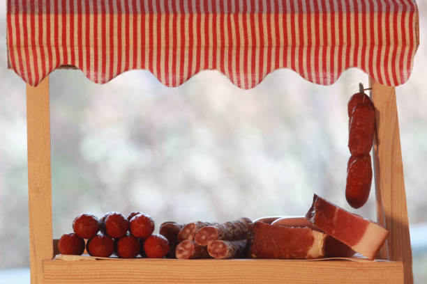 toy market stall with dry sausage and smoked ham, background with copy space