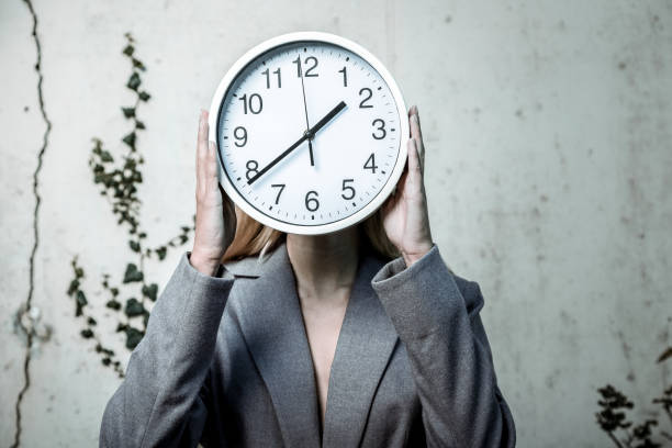 istock Blonde-haired photo model holding clock working for social advert 1070216968